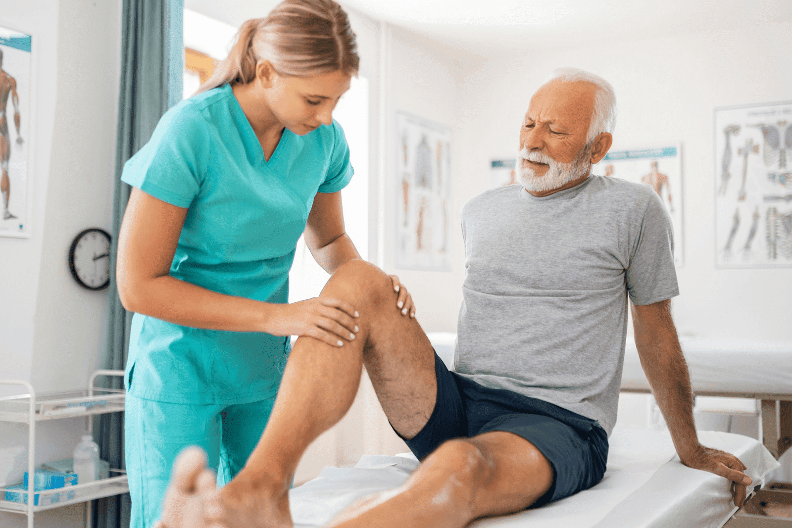 A doctor examines an elderly man’s painful knee