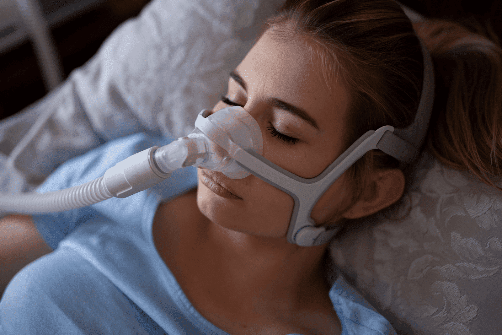 A person sleeping while wearing a CPAP mask, commonly used to treat sleep apnea by keeping the airway open during sleep.