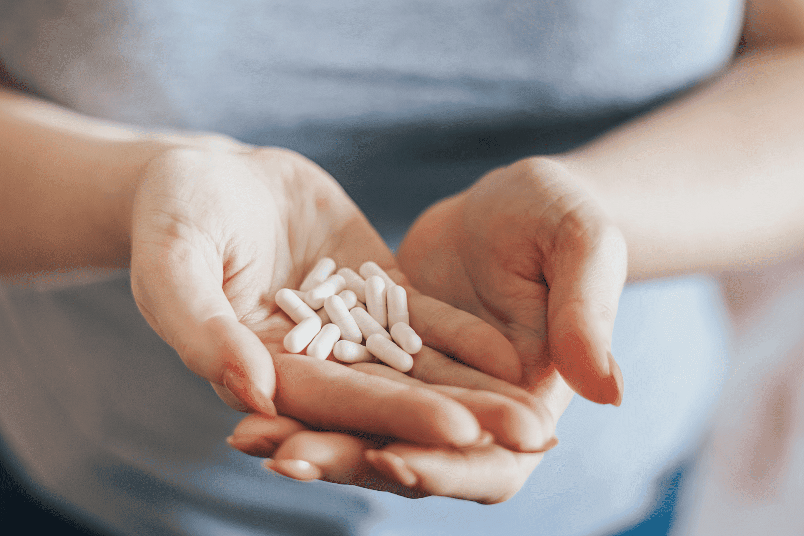 A woman's hand is holding pills