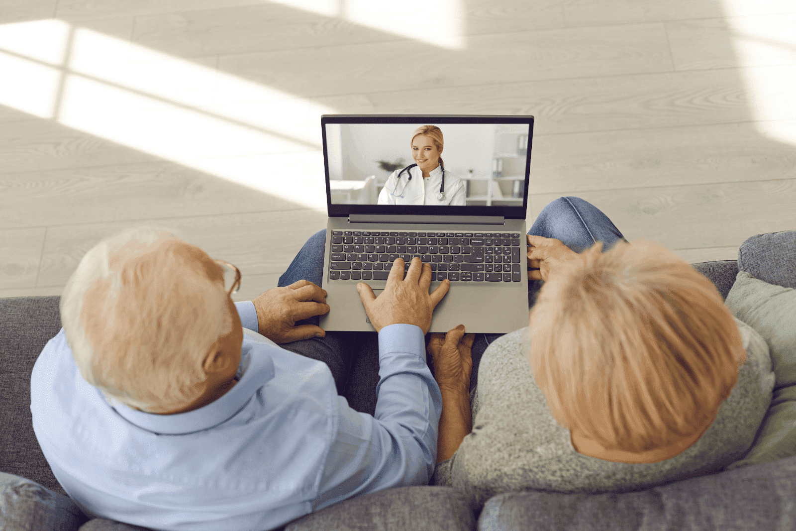 An Elderly couple having an online consultation with a doctor on a laptop.