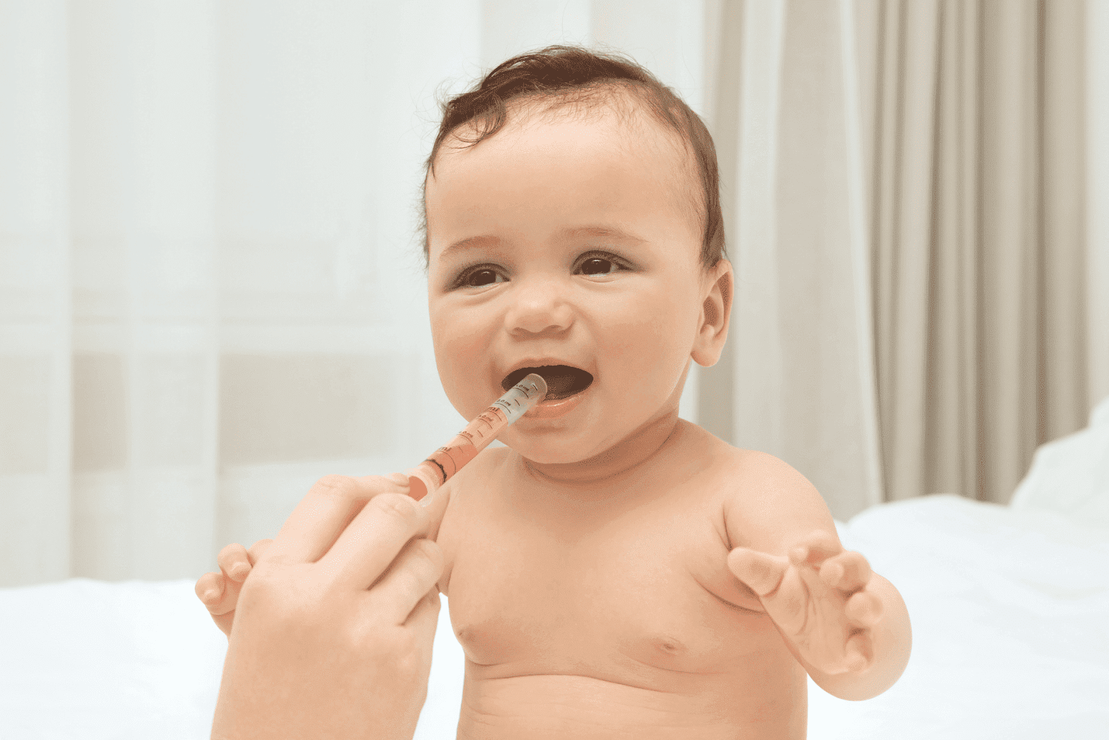 Baby being given liquid medicine with a syringe