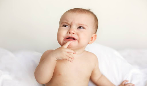 Baby crying with an open mouth, expressing oral discomfort
