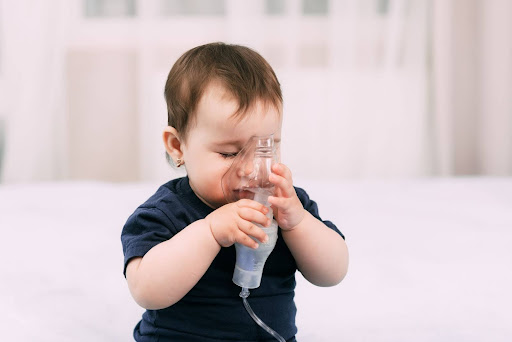 Baby holding nebulizer mask
