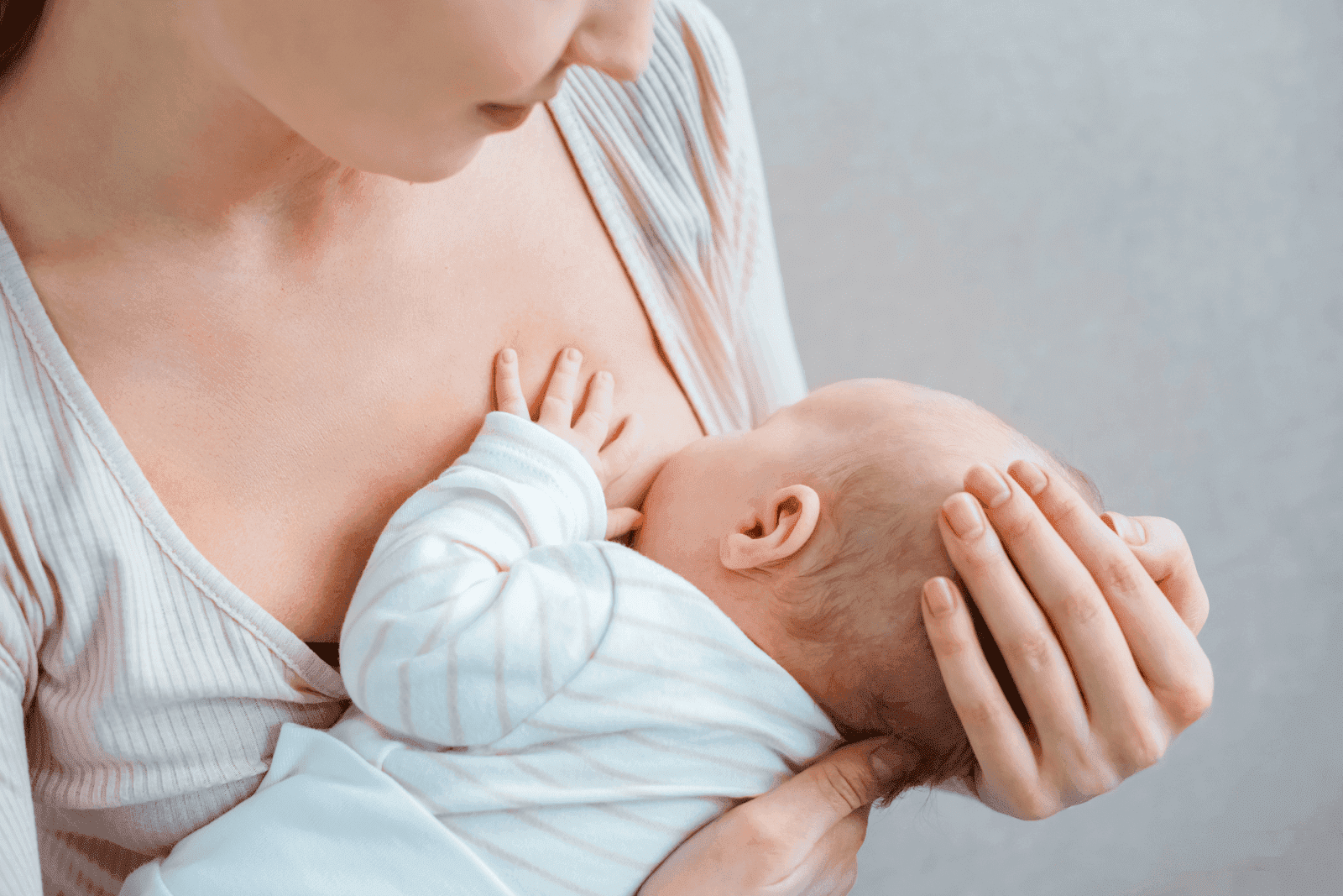 cropped shot of a young woman breastfeeding a baby