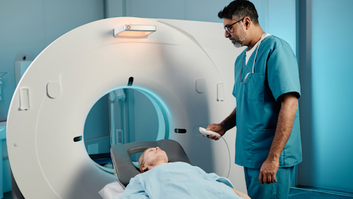 Patient laying down for CT scan and talking to nurse.