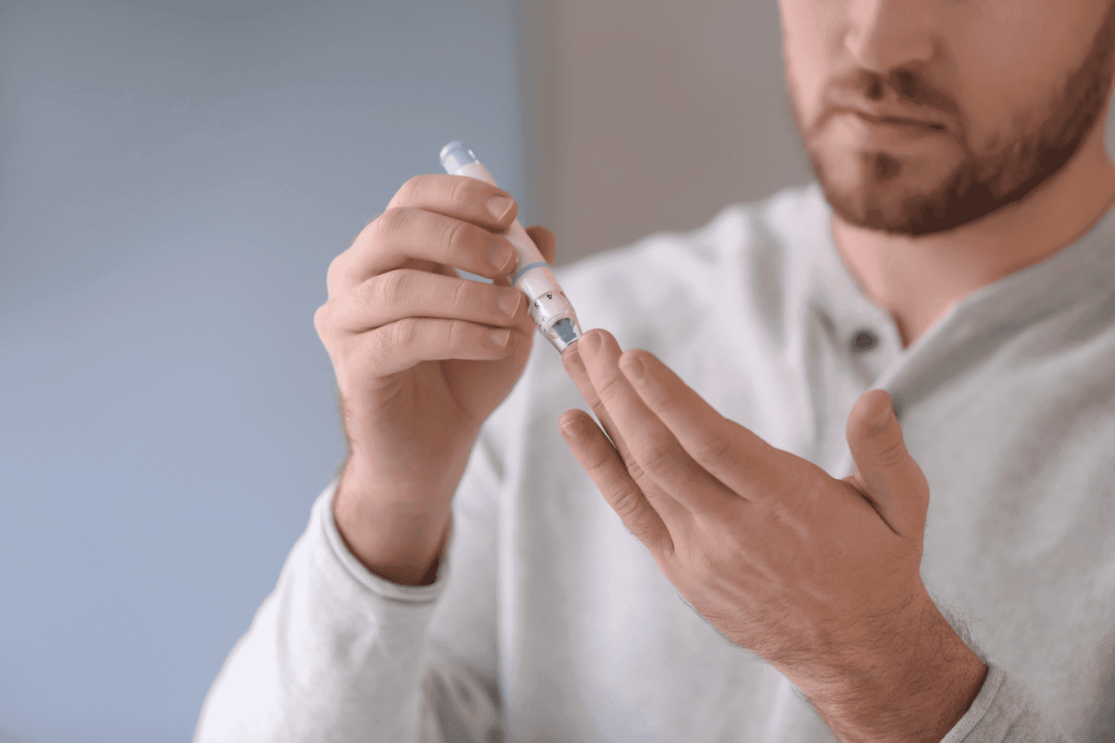 Diabetic Man Taking Blood Sample with Lancet Pen