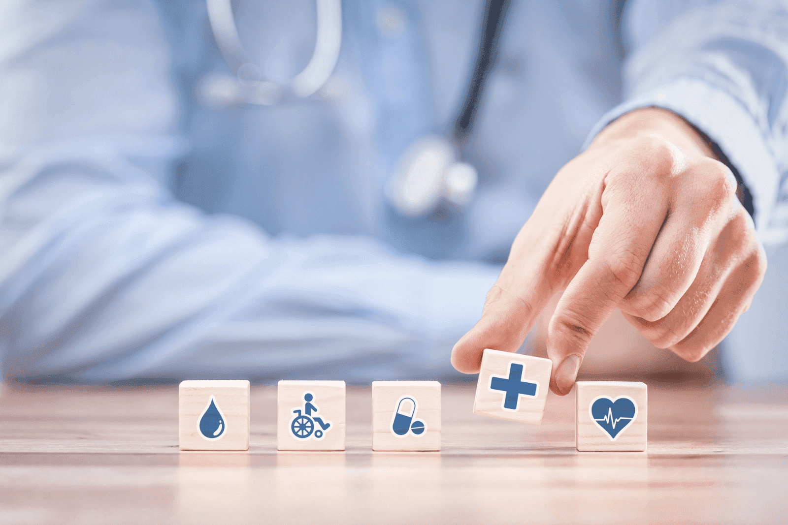 Doctor arranging wooden blocks with health-related icons.