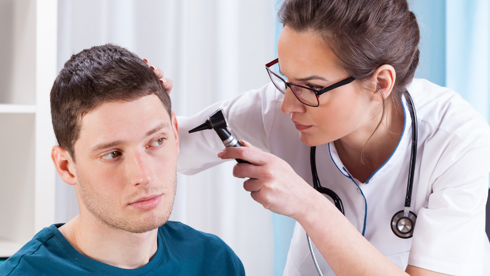 Doctor checking ear of a male patient