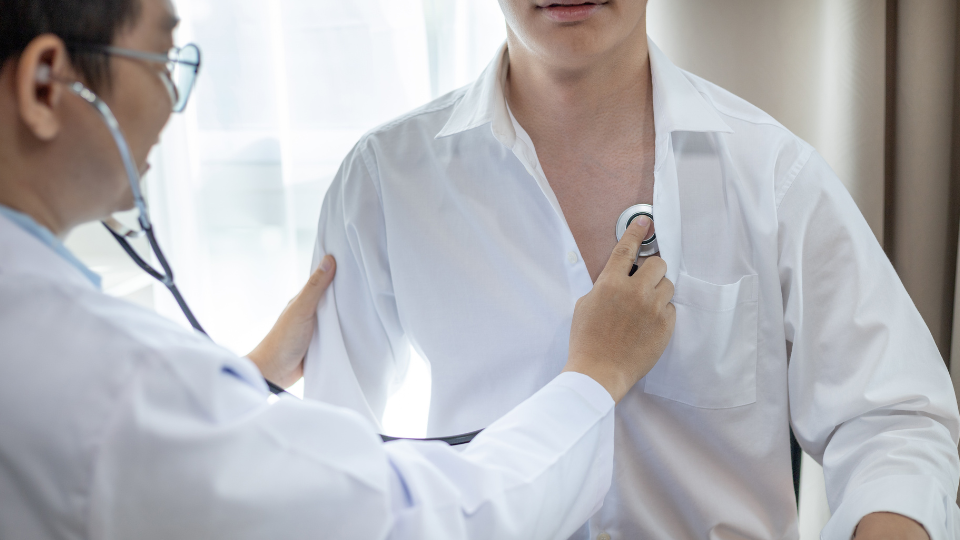 Doctor using stethoscope on patient to check lungs.