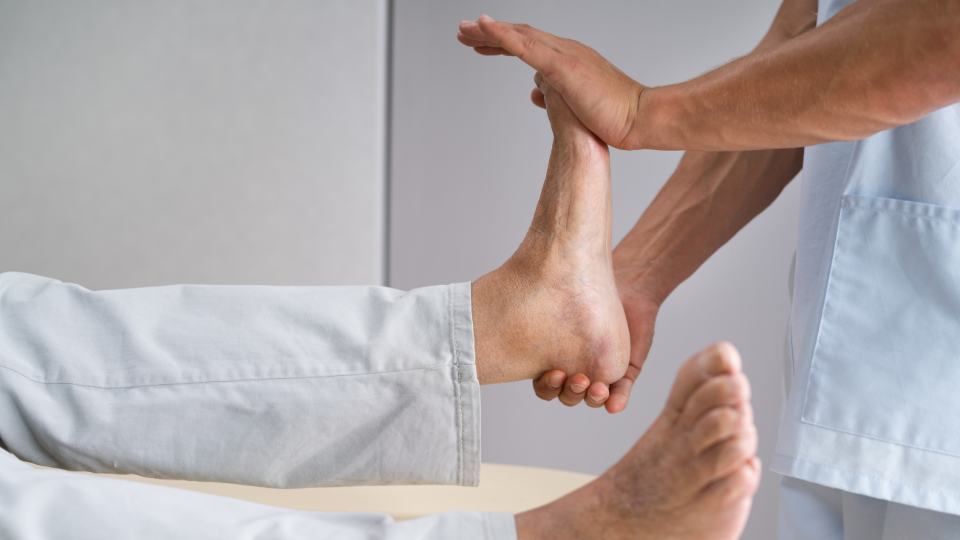 Doctor flexing foot of male patient