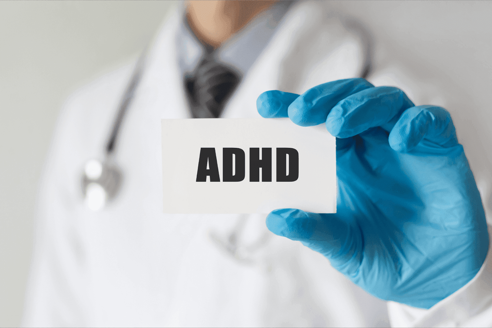 Doctor holding a card labeled “ADHD.”