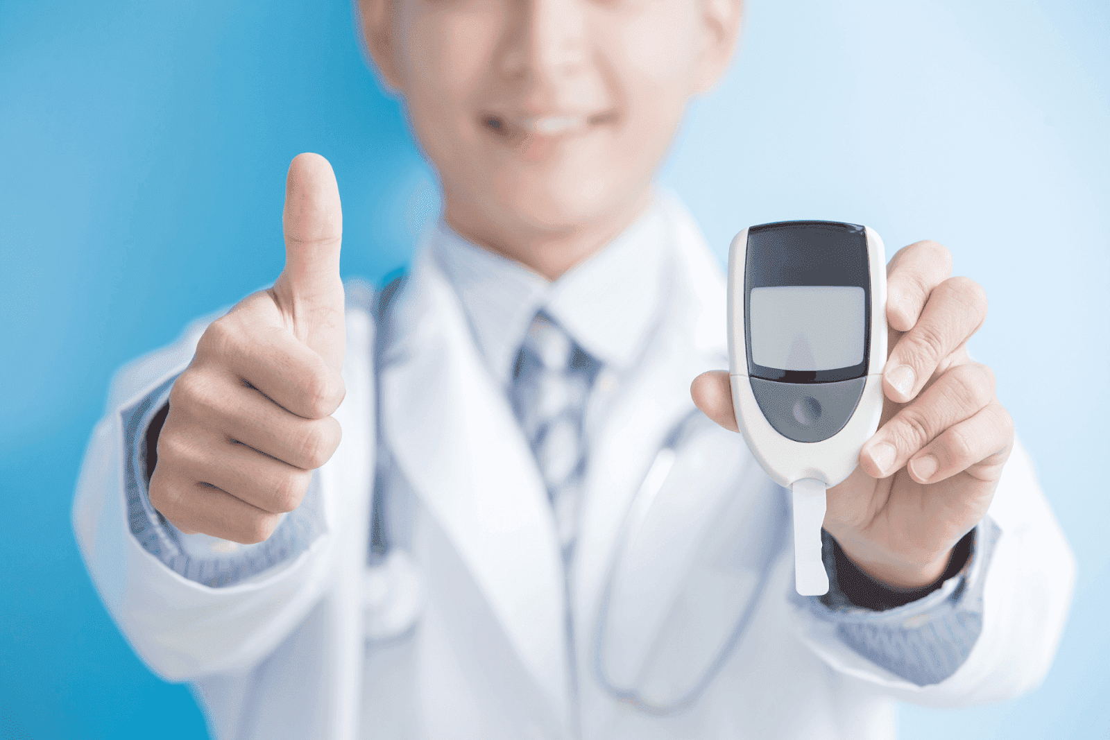 Doctor holding a glucose meter and giving a thumbs up
