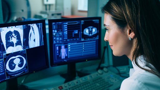 Doctor looking at computer screen filled with CT scans