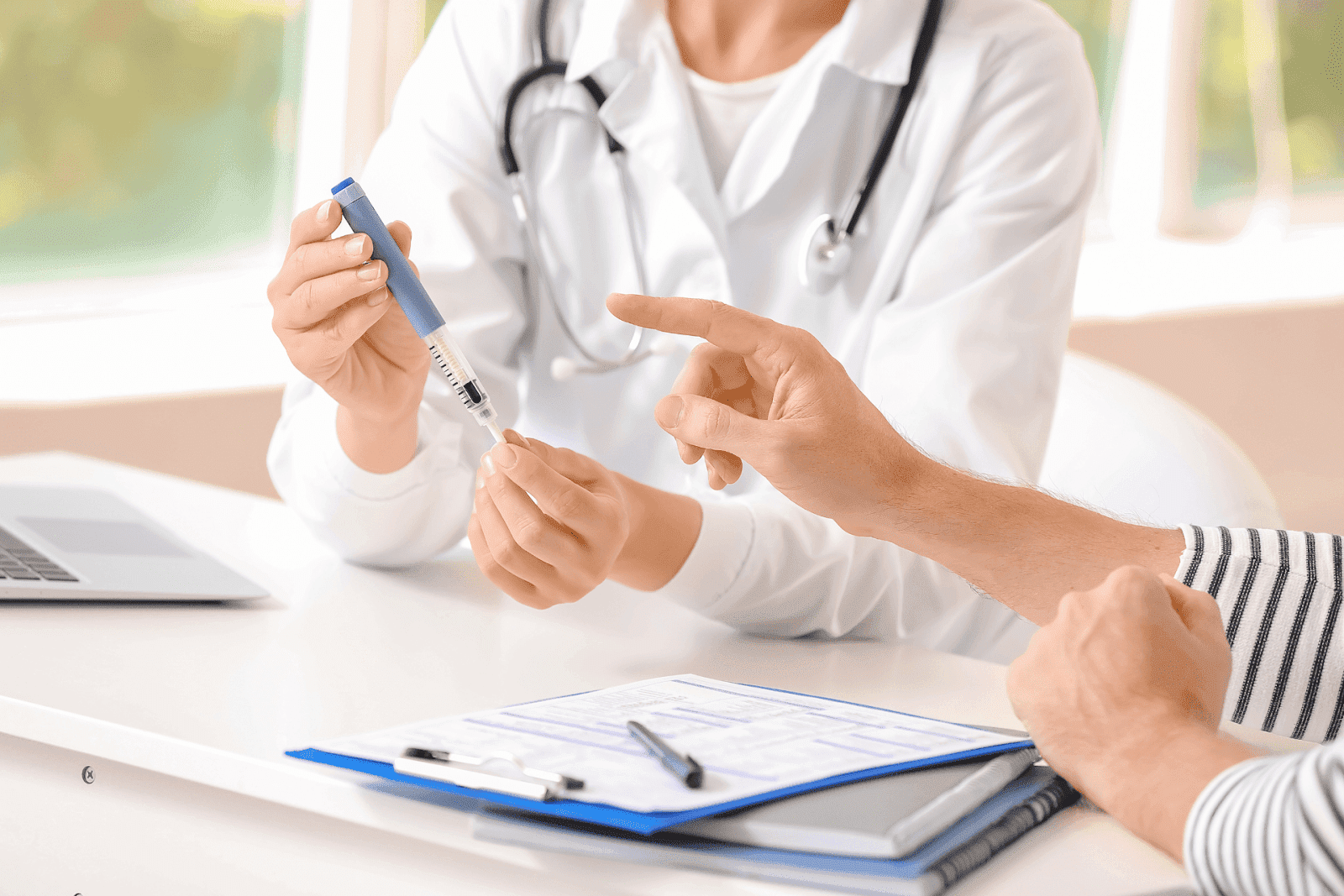Doctor showing a patient how to use an injection pen during an appointment.