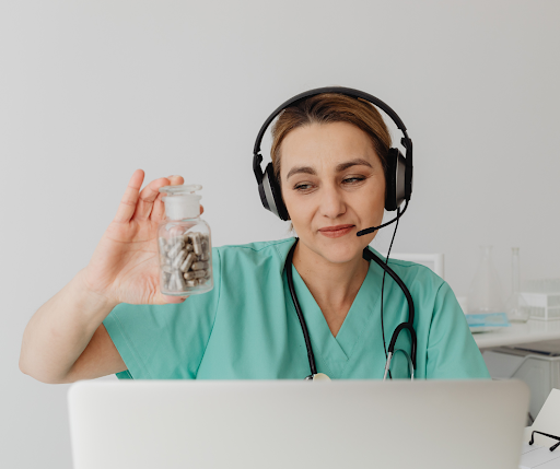 Doctor on telehealth call holding a bottle of medicine.