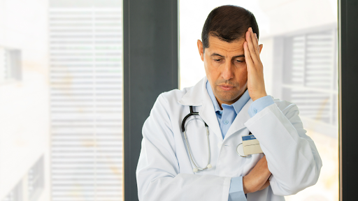 Doctor with left hand on head