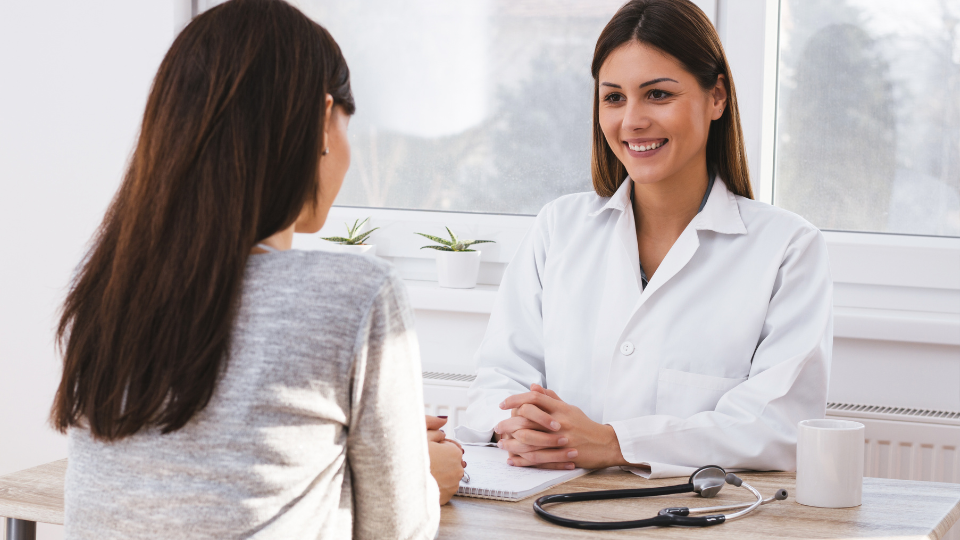 Female doctor and woman sitting and talking.