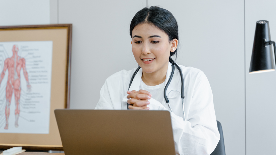 Female doctor on laptop for telehealth video call.