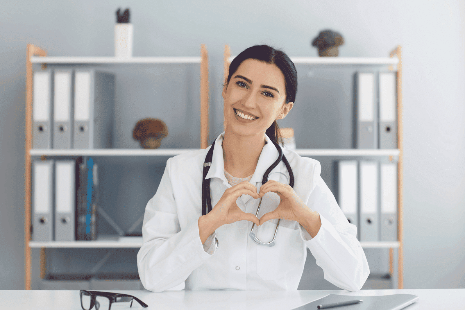 Female doctor smiling and making a heart shape with her hands