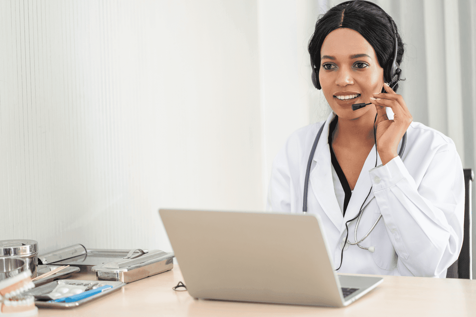 Female doctor wearing a headset speaking during an online consultation.
