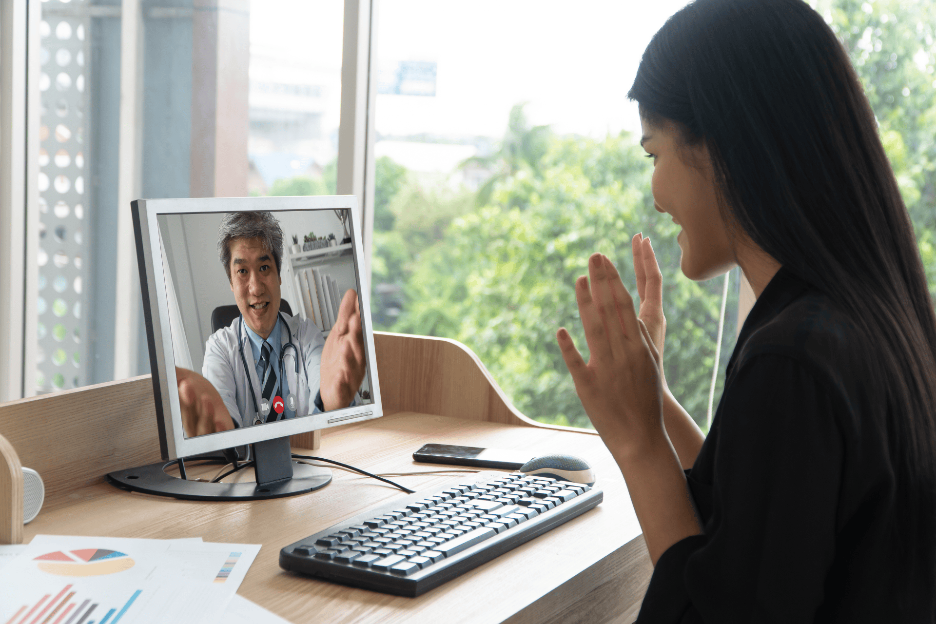 Woman having an online video call with a doctor on her computer.