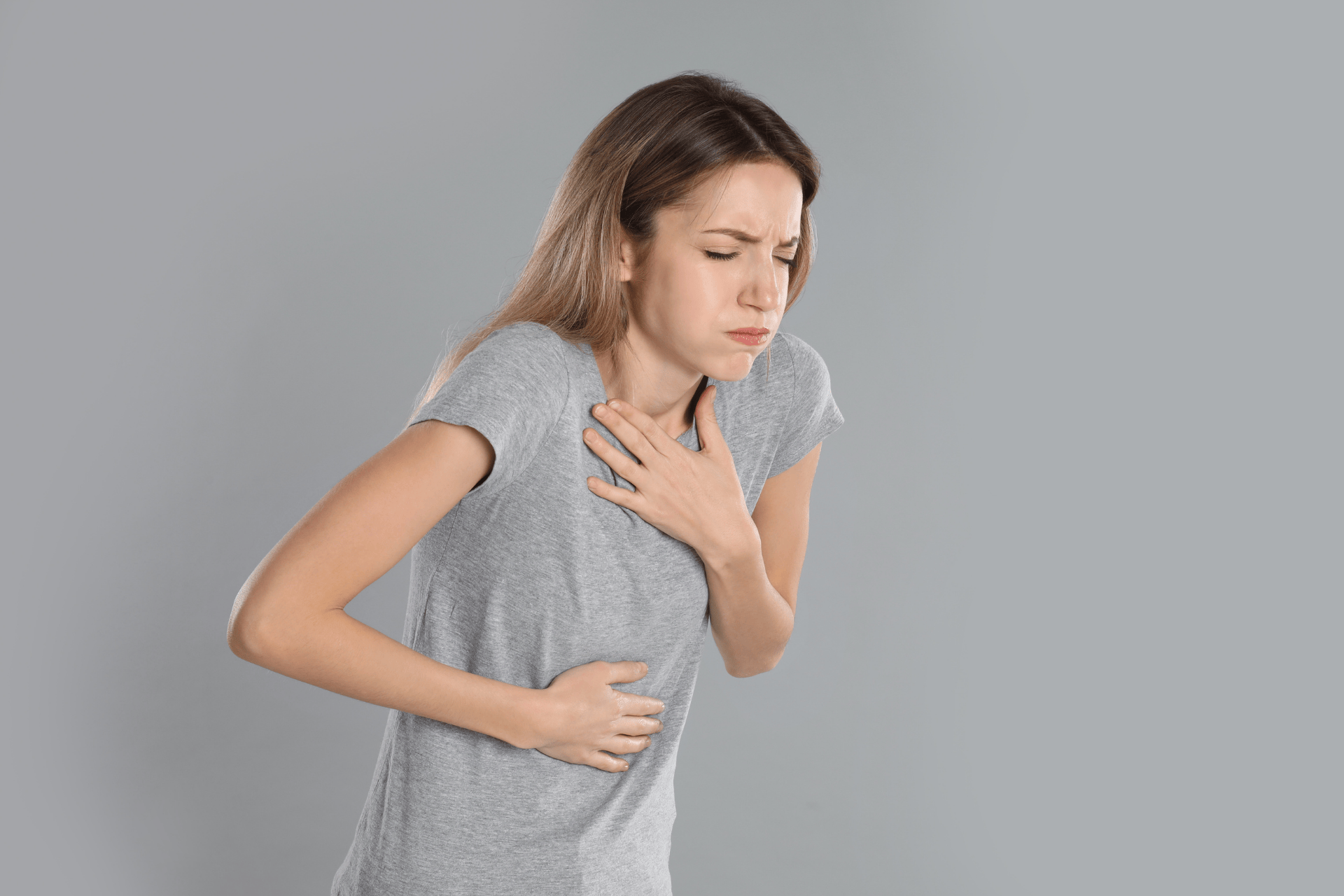 Woman clutching her chest and stomach in pain.