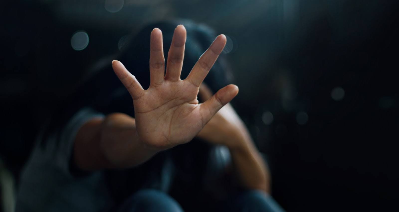 Girl holding hand up in a defensive gesture