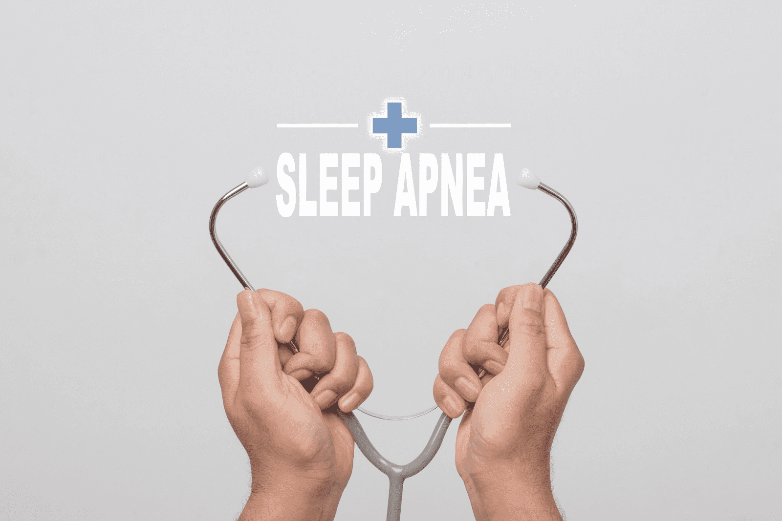 Hands holding a stethoscope with the words “Sleep Apnea” and a medical cross above on a light gray background