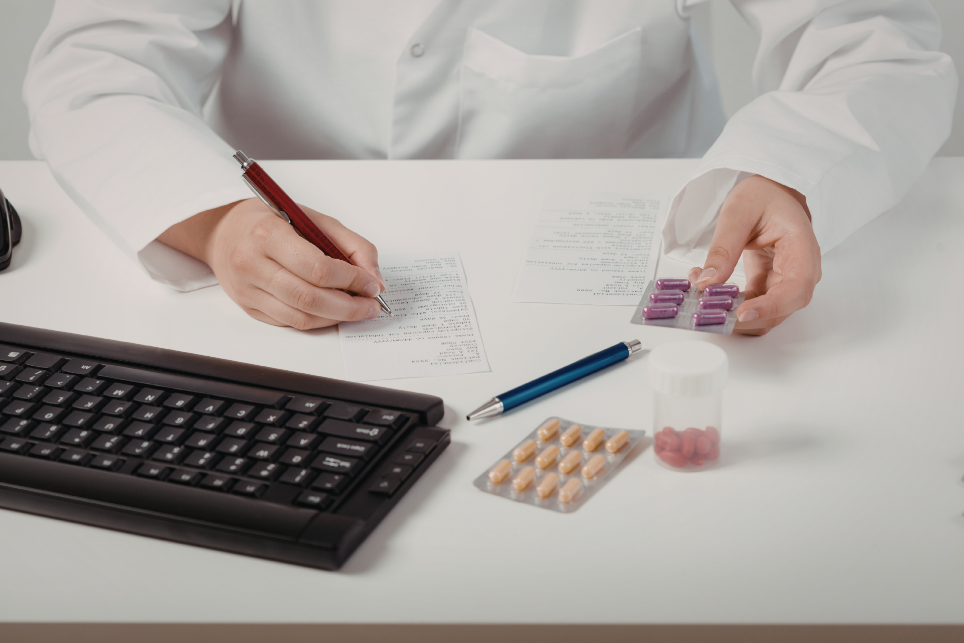 Healthcare professional reviewing prescriptions and medications at a desk