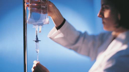 Nurse hanging bag of IV fluids