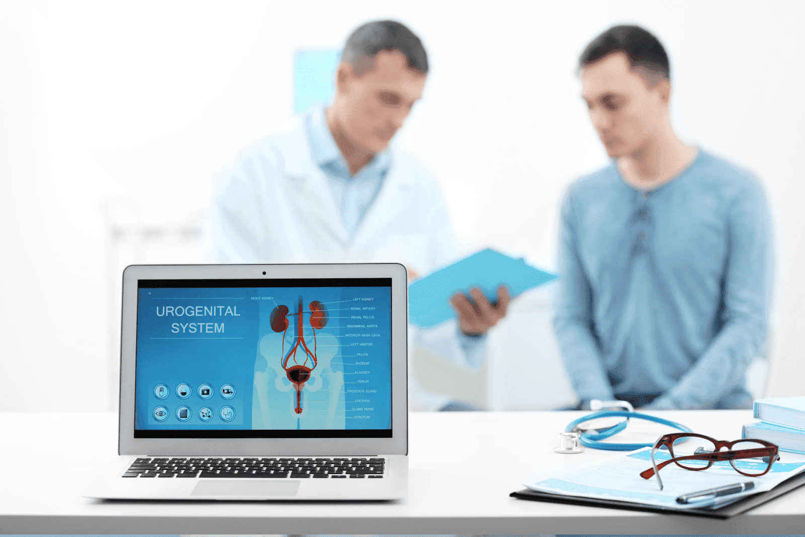 Laptop showing a diagram of the urogenital system with a doctor and patient talking in the background