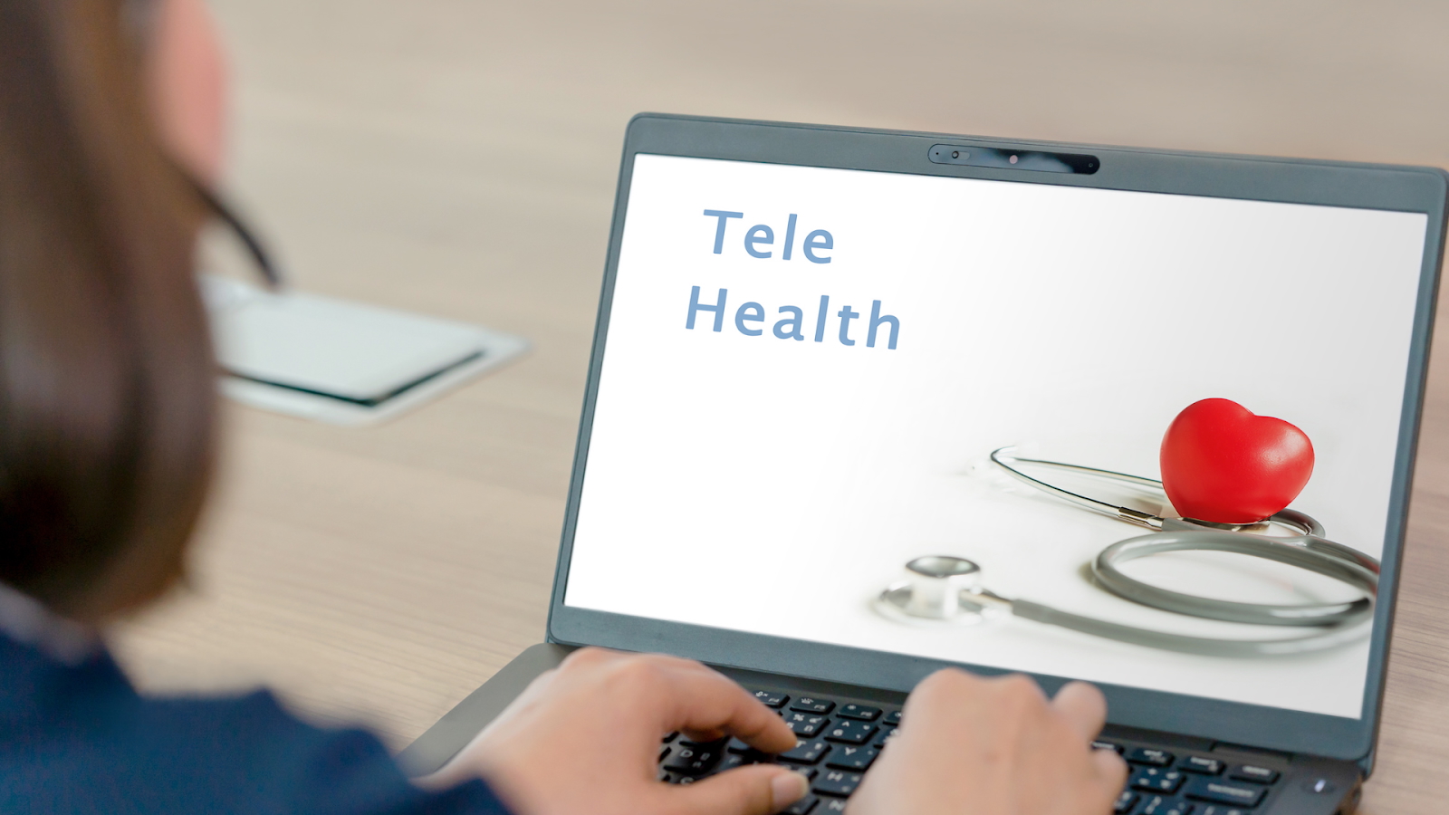Laptop showing an image with "Tele Health" and a stethoscope.