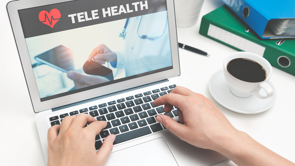 Laptop showing an image saying "Tele Health" on screen