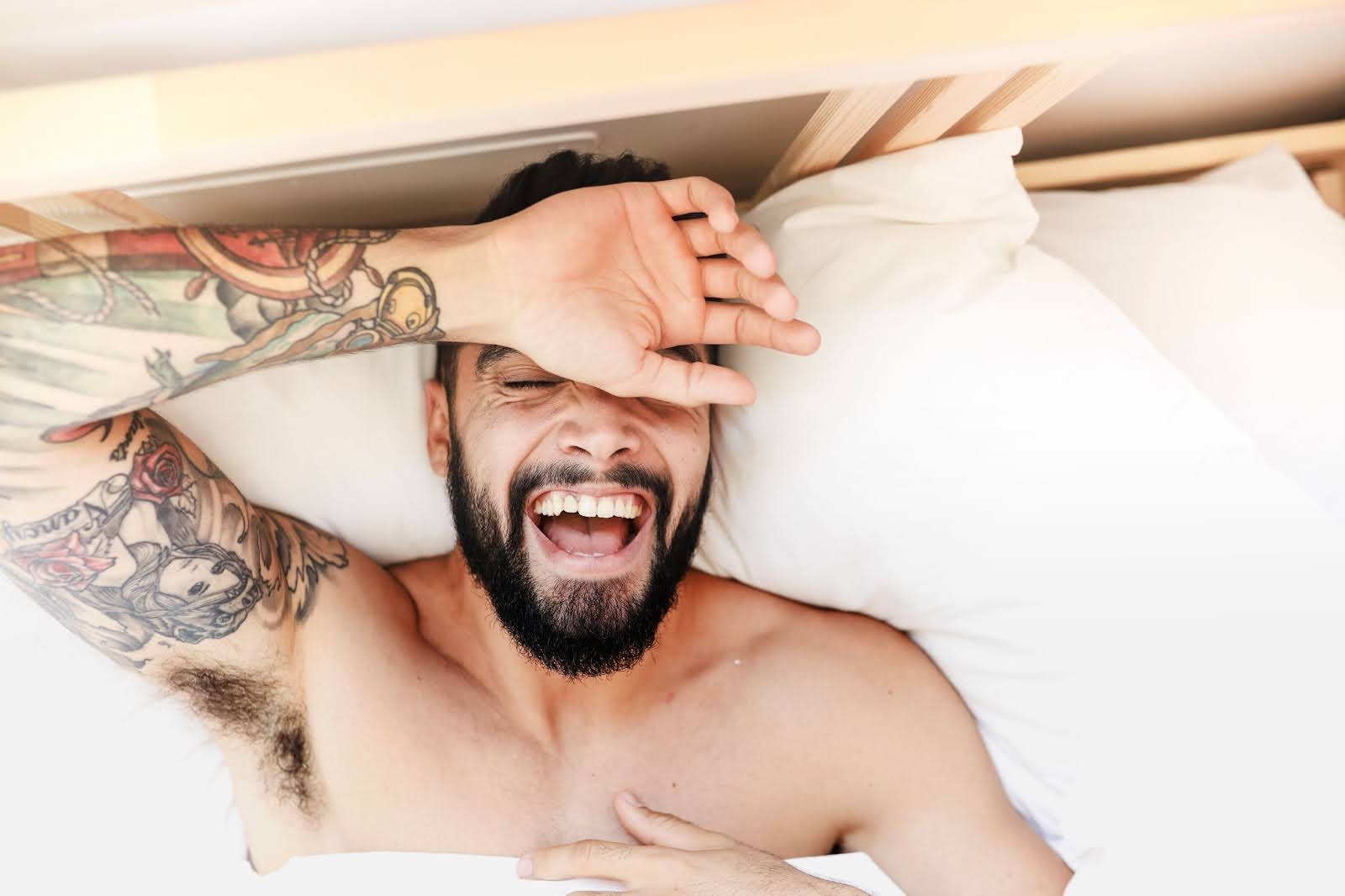 Man laying happily in bed