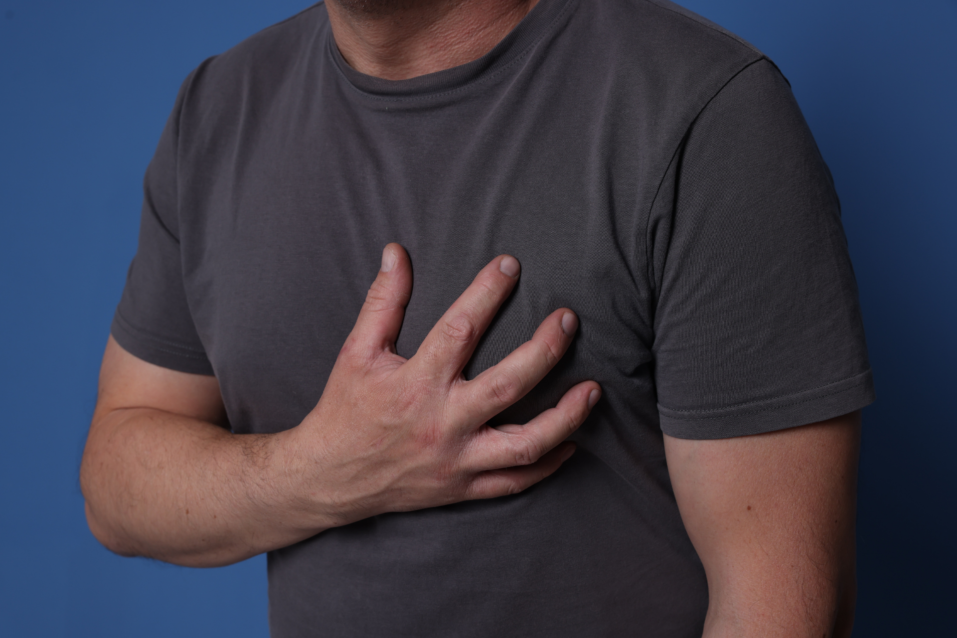 Man holding his chest as if experiencing chest pain