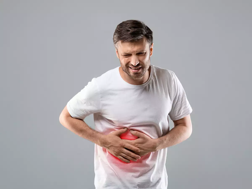 image indicating a man holding his upper abdomen due to liver pain
