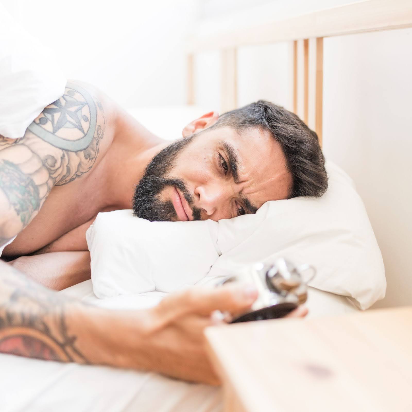 Man in bed looking at the clock