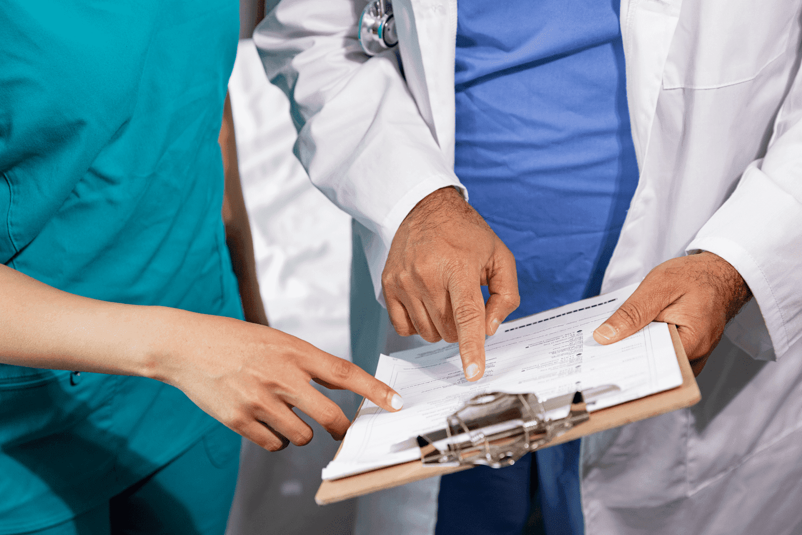 Medical professionals pointing at a clipboard with lab reports