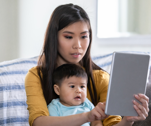 Mother and baby using tablet for telehealth appointment.