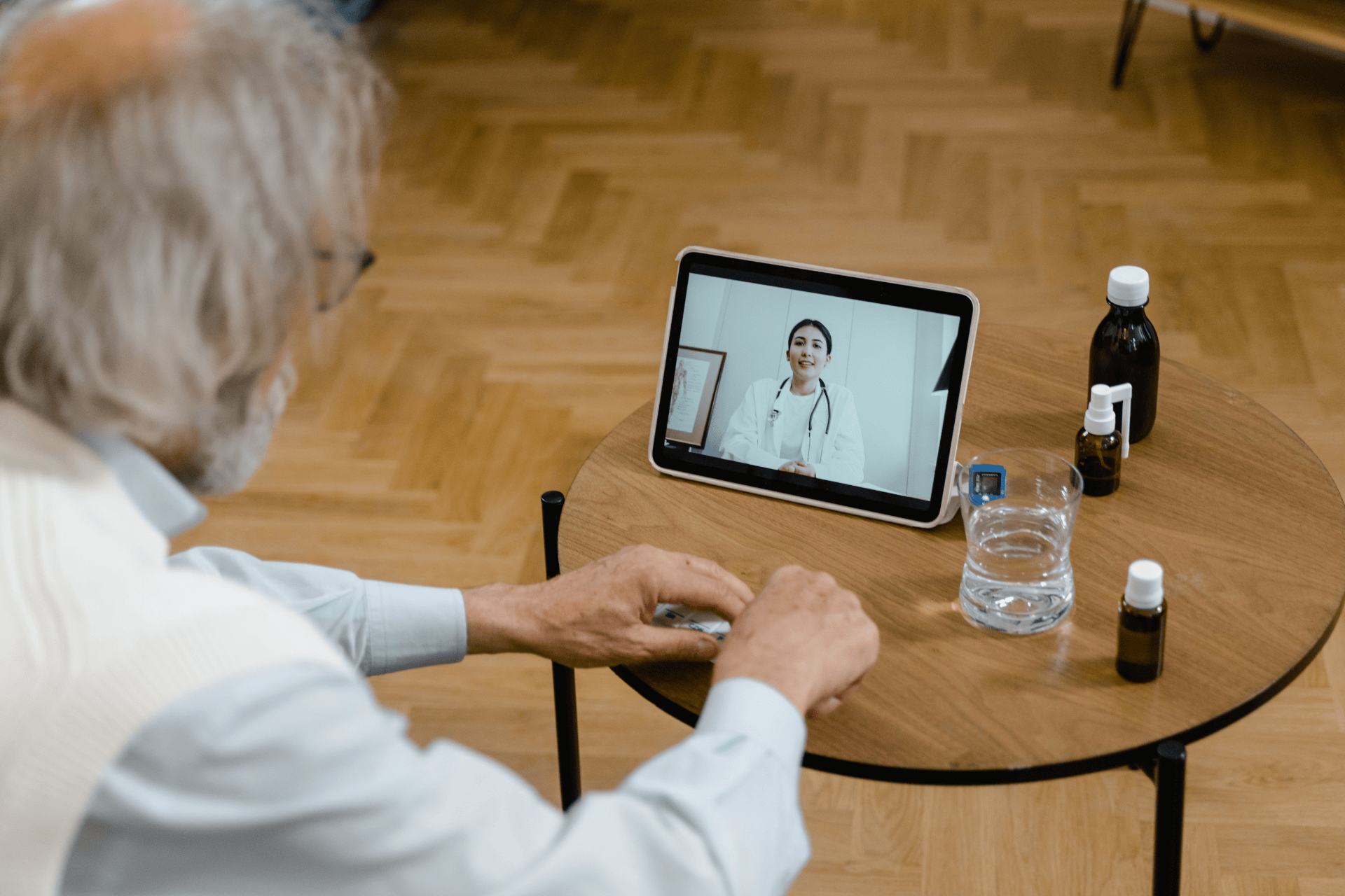 Older man having an online video consultation with a doctor on a tablet.