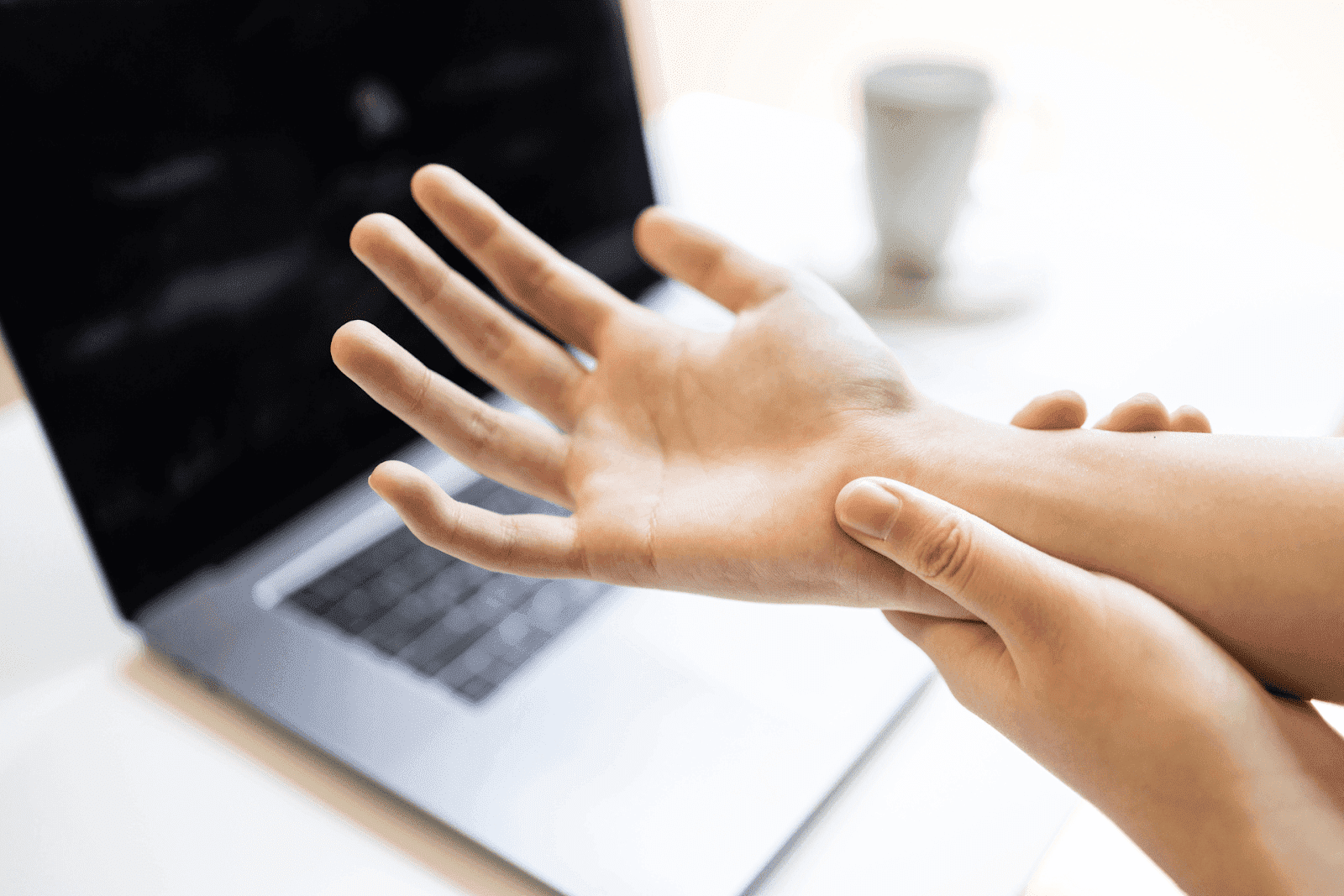 Person holding wrist, showing neuropathy pain.