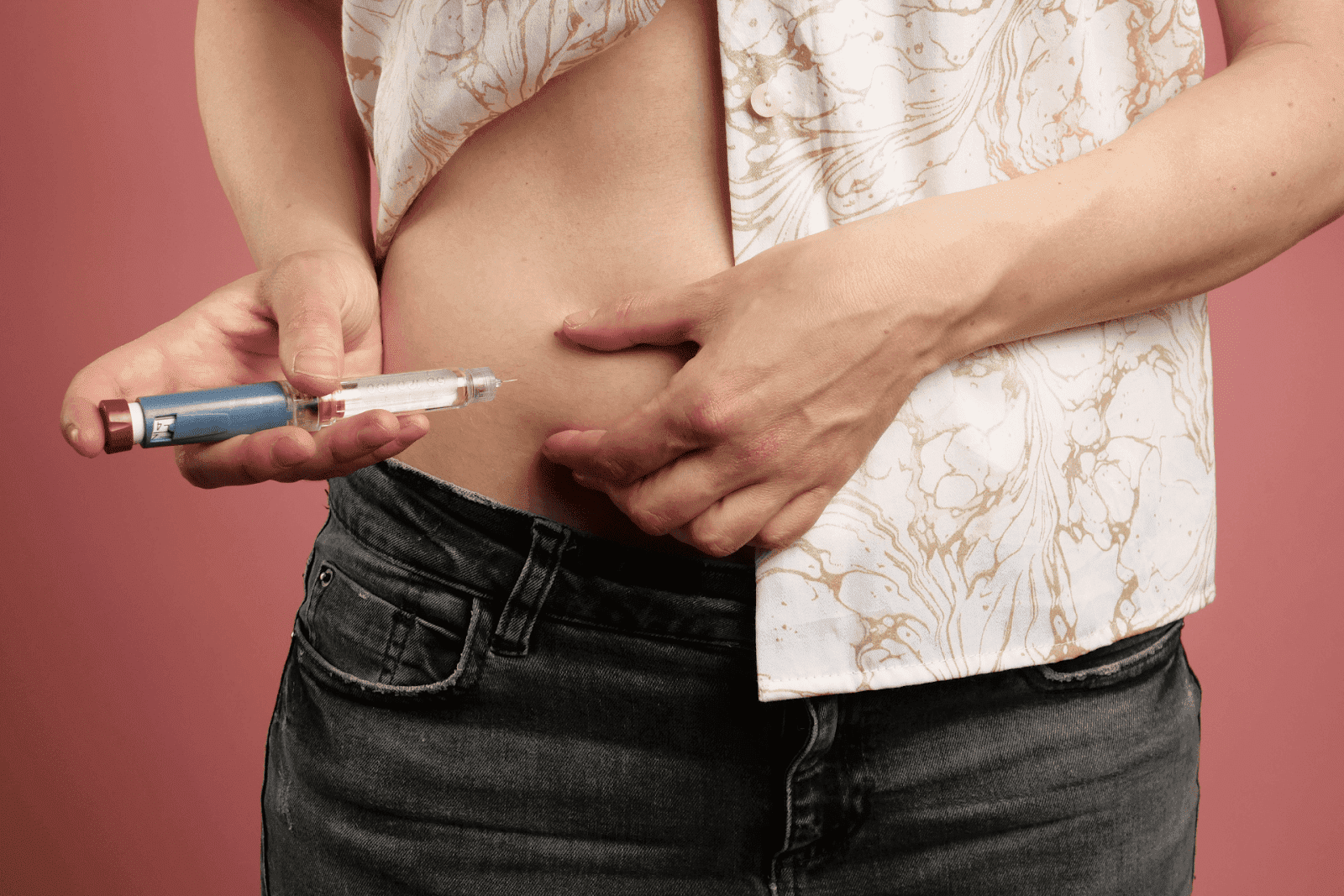 Person injecting insulin into abdomen using an insulin pen.