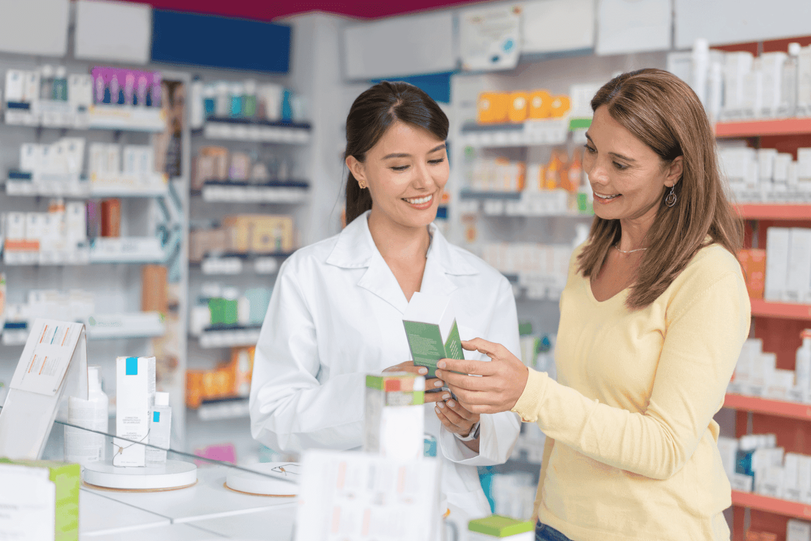Pharmacist assisting a customer by explaining medication details in a pharmacy