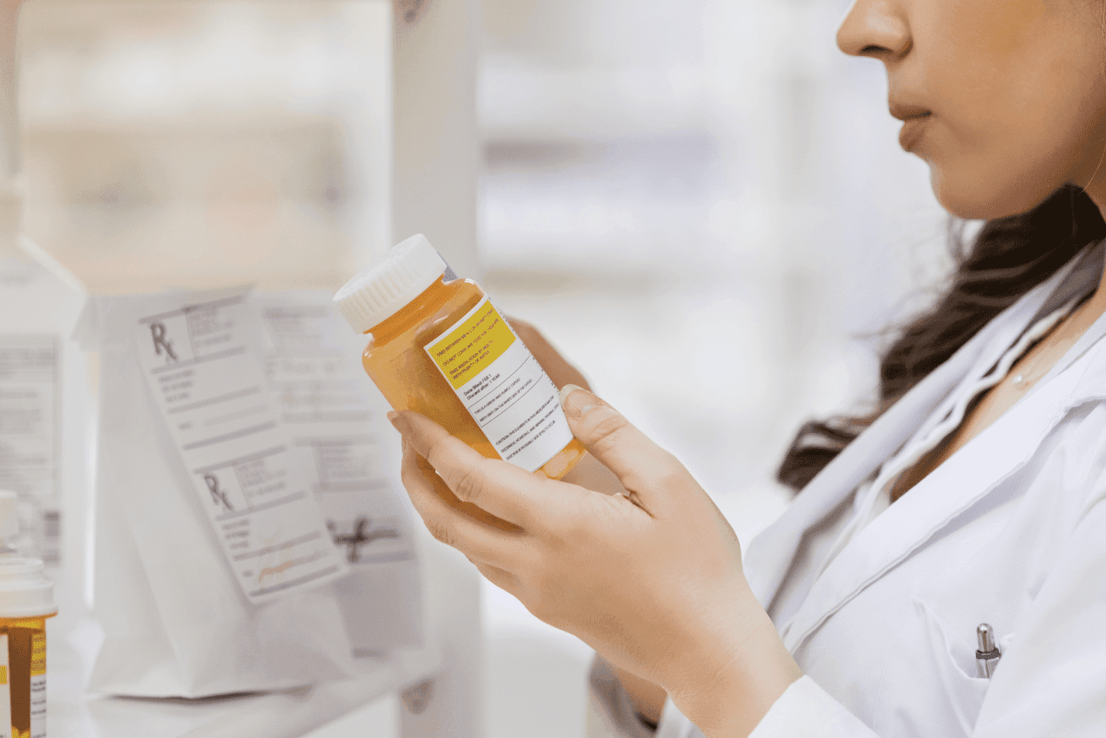 Pharmacist checking a prescription pill bottle in a pharmacy