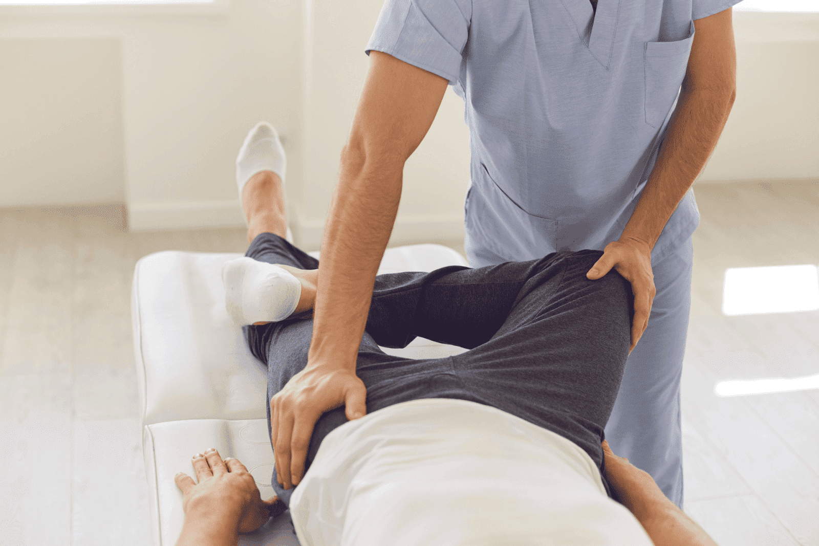 Physiotherapist examining a patient on a treatment table.
