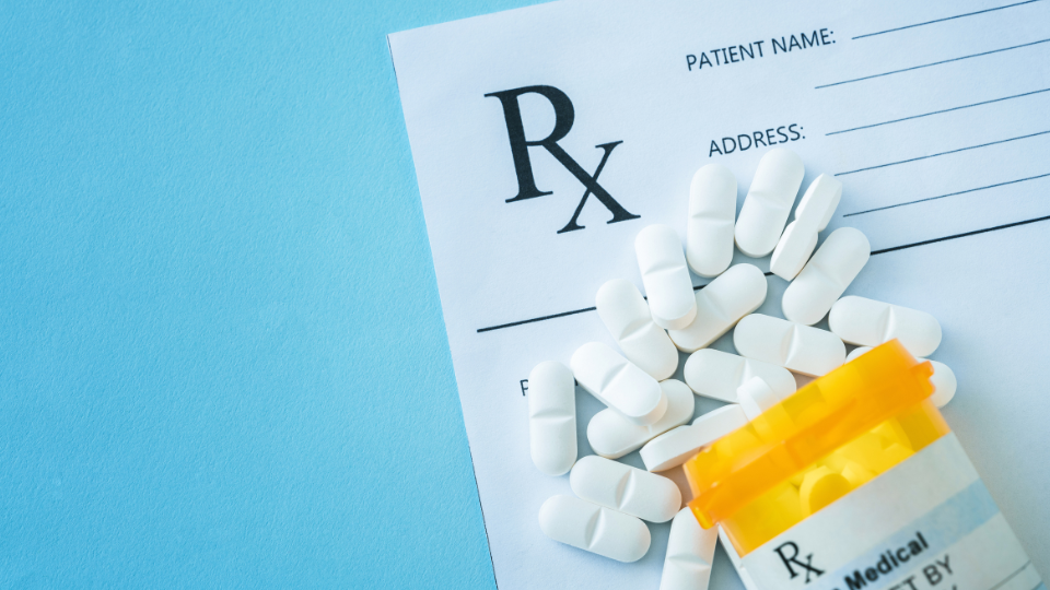 Prescription form with white pills and pill bottle.