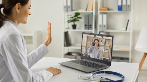 Female doctor using laptop to speak with female patient
