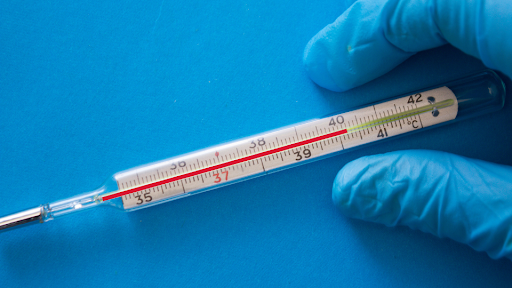 Thermometer showing high fever on blue background