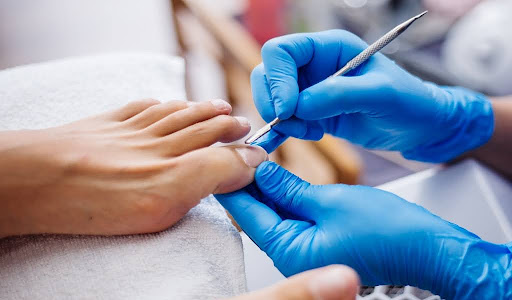 Close-up of hygienic toenail care with gloves and tools.