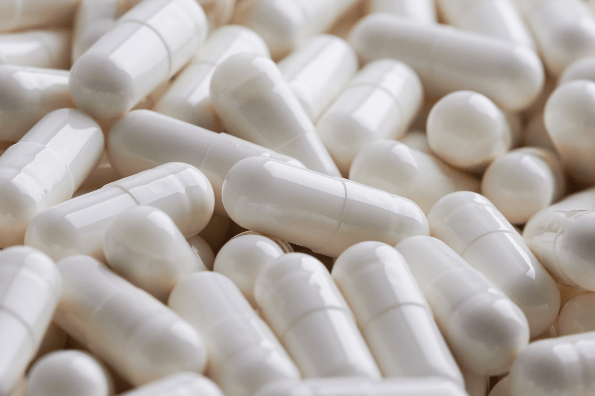 Close-up of white capsules piled together.